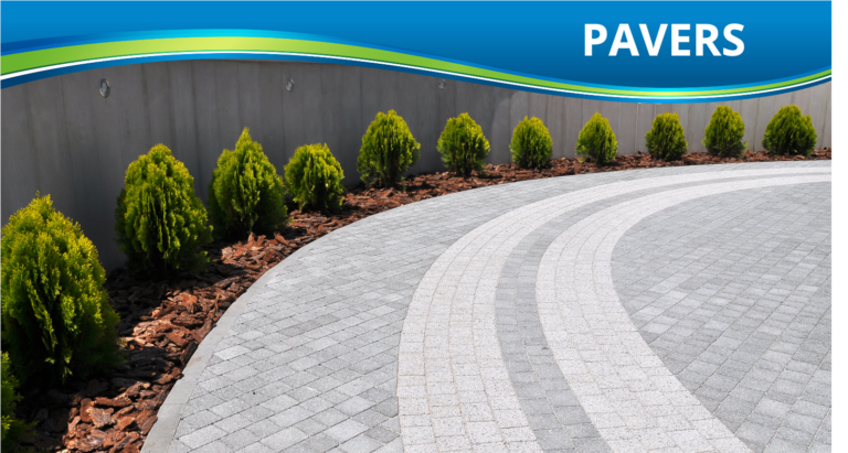 A beautiful driveway made with high-quality pavers next to several small trees.